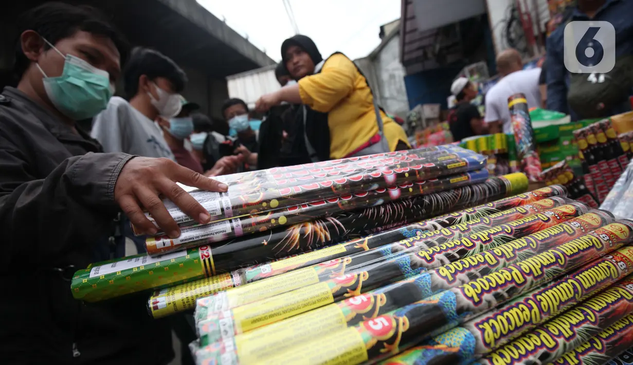 Warga memilih kembang api yang dijajakan oleh pedagang di Pasar Asemka, Jakarta, Kamis (30/12/2021). Meski Larangan Tahun Baru 2022 diberlakukan untuk membatasi mobilitas, namun masih banyak warga yang berburu kembang api baik untuk dijual maupun digunakan sendiri. (Liputan6.com/Johan Tallo)