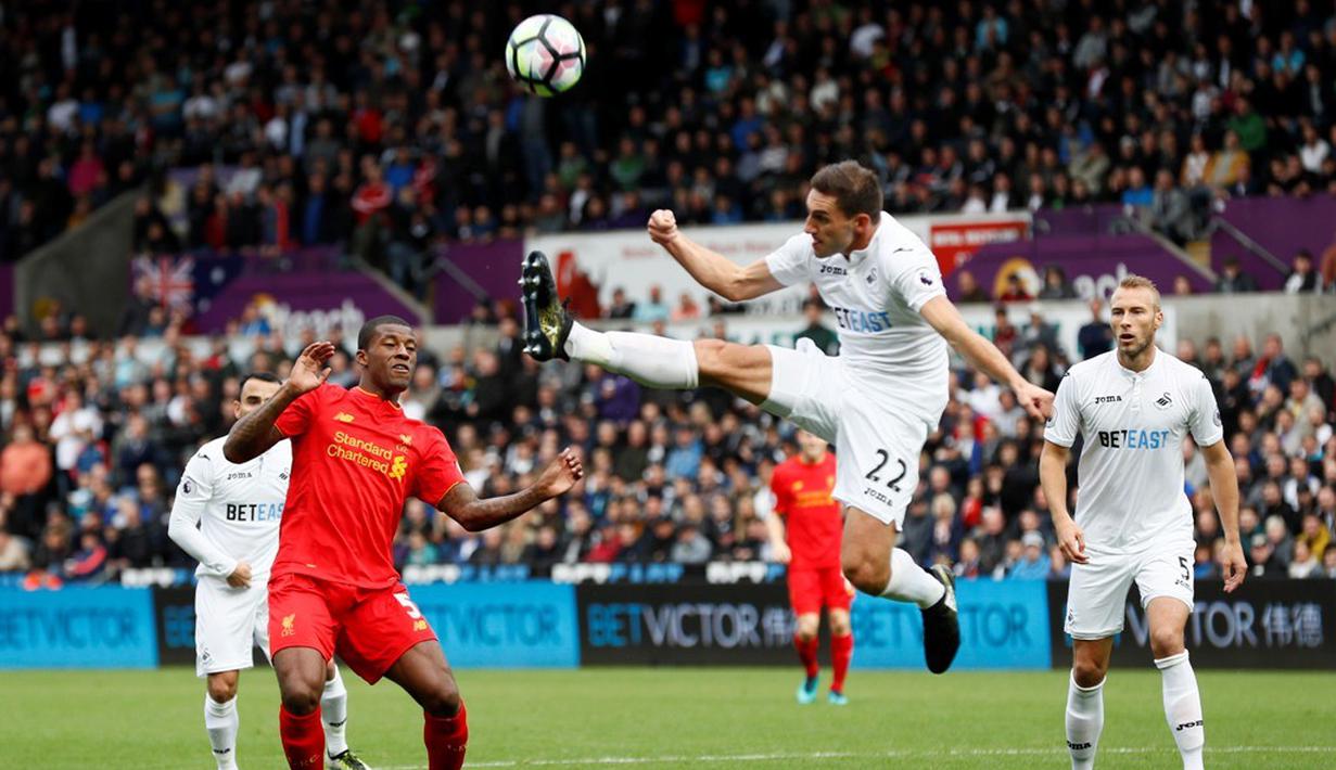 Pemain Swansea City, Angel Rangel, membuang bola saat melawan Liverpool dalam laga Premier League, di Liberty Stadium, Sabtu (1/10/2016). (Reuters/Stefan Wermuth)