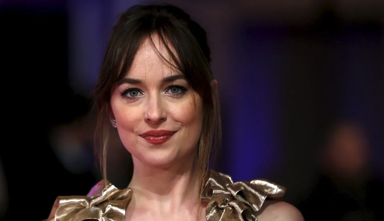 Senyum Dakota Johnson saat menghadiri pemutaran perdana film "How To Be Single" di London, Inggris, Selasa (9/2). Wanita 26 tahun itu memilih untuk tampil glamour mengenakan dress emas berkilauan ala Dewi Yunani. (REUTERS/Neil Hall)