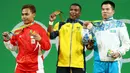 Lifter Indonesia Eko Yuli Irawan menunjukkan medali perak yang diraihnya bersama Oscar Figueroa (tengah), peraih medali emas dari Kolombia dan Farkhad Kharki dari Kazakhstan, peraih medali perunggu di Olimpiade Rio 2016, Senin (8/8). (REUTERS/Yves Herman)