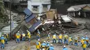 Tim penyelamat melakukan operasi pencarian di lokasi longsoran lumpur di Izusan di Atami, Jepang, Minggu (4/7/2021). Derasnya lumpur menerjang sebagian kota pada Sabtu pagi setelah berhari-hari hujan lebat, menyapu rumah-rumah lereng bukit. (Kyodo News via AP)