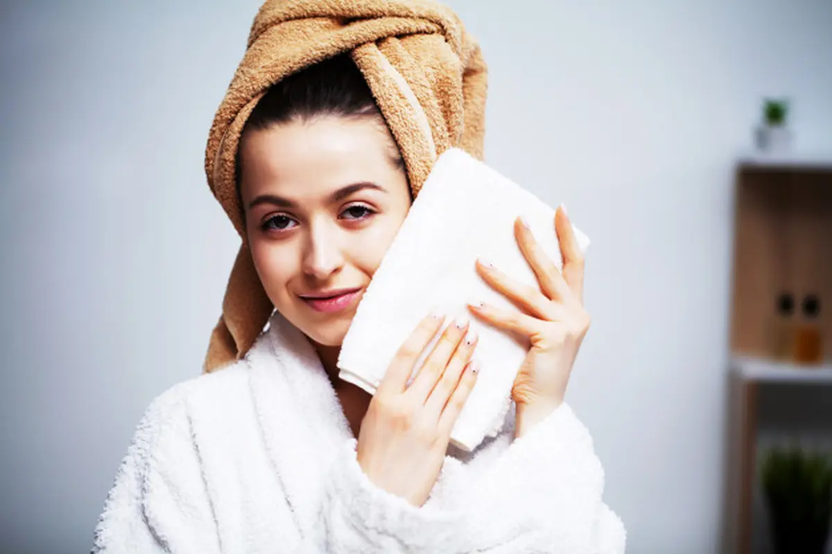 Gambar Ilustrasi Wanita Menepuk Wajahnya Dengan Handuk Setelah Mencuci Muka