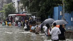 Orang-orang berjalan melewati jalan yang tergenang air setelah hujan lebat di Mumbai, India, Rabu (23/9/2020). Musim hujan di India berlangsung dari Juni hingga September. (AP Photo/Rajanish Kakade)