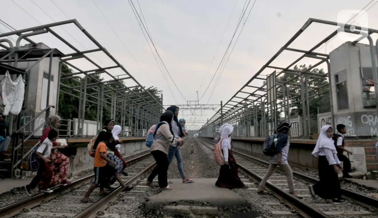Warga menyeberangi perlintasan kereta di dekat Stasiun Buaran lama, Jakarta, Selasa (8/10/2019). Stasiun Buaran lama sudah tidak difungsikan sejak November 2018 akibat adanya Stasiun Buara baru. (merdeka.com/Iqbal Nugroho)
