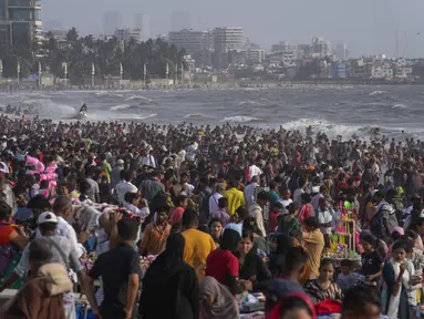 Warga memadati pantai Juhu di Laut Arab pada hari yang panas dan lembab di kota Mumbai, India, 8 Mei 2022. Musim panas yang terik di India menambah risiko baru tahun ini. Suhu di India melebihi 40 derajat Celcius di banyak daerah. (AP Photo/Rafiq Maqbool)