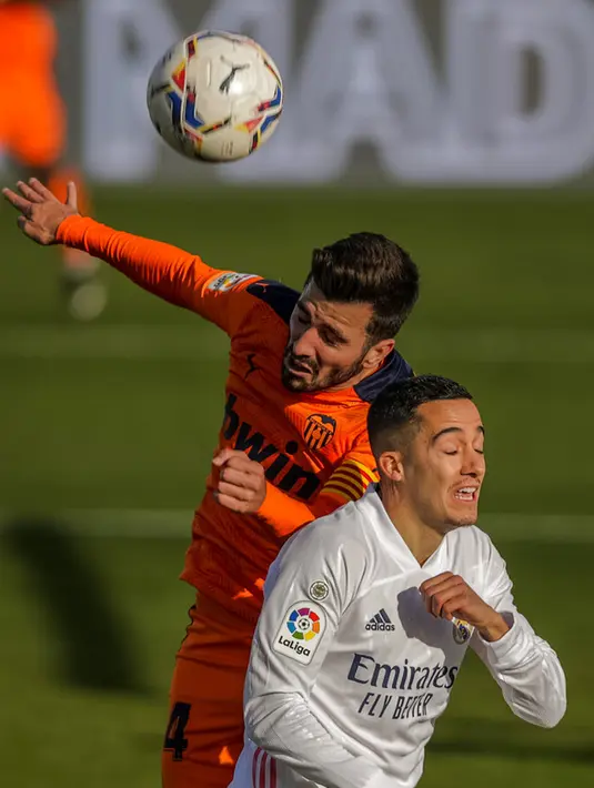 Pemain Real Madrid Lucas Vazquez (depan) berebut bola dengan pemain Valencia Jose Gaya pada pertandingan Liga Spanyol di Stadion Alfredo Di Stefano, Madrid, Spanyol, Minggu (14/2/2021). Real Madrid menggeser Barcelona di peringkat dua klasemen usai menaklukkan Valencia 2-0. (AP Photo/Manu Fernandez)