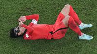 Reaksi kesakitan pemain Korea Selatan,&nbsp;Son Heung-min setelah mendapatkan tekel dari pemain Brasil saat babak 16 besar Piala Dunia yang berlangsung di 974 Stadium, Selasa (06/12/2022). (AP/Pavel Golovkin)