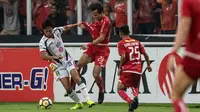 Gelandang Mitra Kukar, Arif Suyono, berebut bola dengan bek Persija Jakarta, Rezaldi Hehanussa, pada laga Liga 1 di SUGBK, Jakarta, Minggu (9/12). Persija menang 2-1 atas Mitra. (Bola.com/Yoppy Renato)