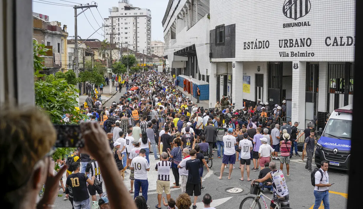 Warga Brasil mengantre untuk memberikan penghormatan terakhir kepada legenda sepak bola Brasil Pele di stadion Vila Belmiro di Santos, Brasil, Senin, 2 Januari 2023. Jenazah Pele akan dibawa melintas jalan-jalan Kota Santos dan melewati rumah sang ibunda Celeste yang berusia 100 tahun. Media Brasil menyebut ibu Pele tidak dalam keadaan sadar. (AP Photo/Matias Delacroix)