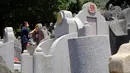 Seorang wanita membersihkan makam kerabat saat Festival Ching Ming atau Hari Sapu Makam di Hong Kong, Selasa (5/4/2022). Ribuan warga Hong Kong memberi hormat kepada leluhur dan kerabat mereka selama festival tahunan ini. (AP Photo/Vincent Yu)