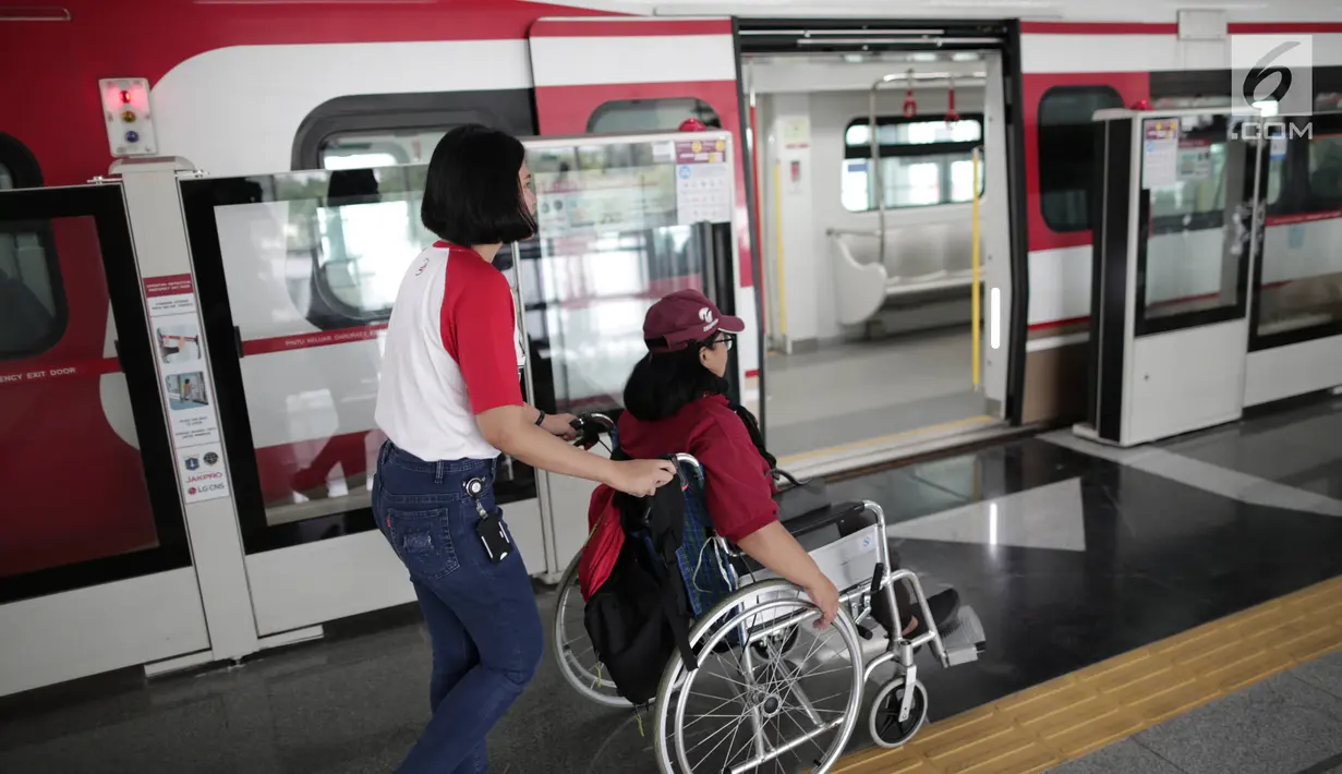 Petugas membantu penyandang disabilitas naiki ke kereta Lintas Rel Terpadu (LRT) di Stasiun LRT Veldrome, Jakarta, Sabtu (27/4). Kegiatan yang diikuti Jakarta Barrier Free Tourism (JBFT) itu untuk mengenalkan LRT lebih dekat, terutama kepada penyandang disabilitas. (Liputan6.com/Faizal Fanani)