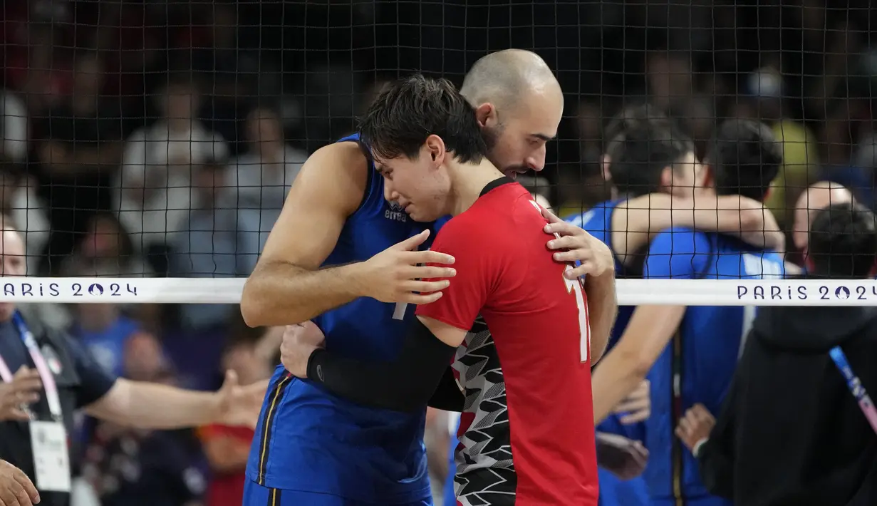 Pemain voili Italia, Gianluca Galassi menghibur Ran Takahashi, dari Jepang, pada akhir pertandingan bola voli perempat final putra Olimpiade Paris 2024 di South Paris Arena, Senin, 5 Agustus 2024. (AP Photo/Dolores Ochoa)