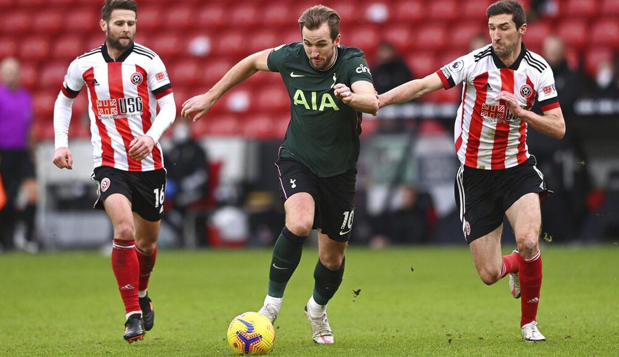 Striker Tottenham Hotspur, Harry Kane, berusaha melewati pemain Sheffield United pada laga Liga Inggris di Stadion Bramall Lane, Minggu (17/1/2021). Tottenham Hotspur menang dengan skor 3-1. (Stu Forster/Pool via AP)