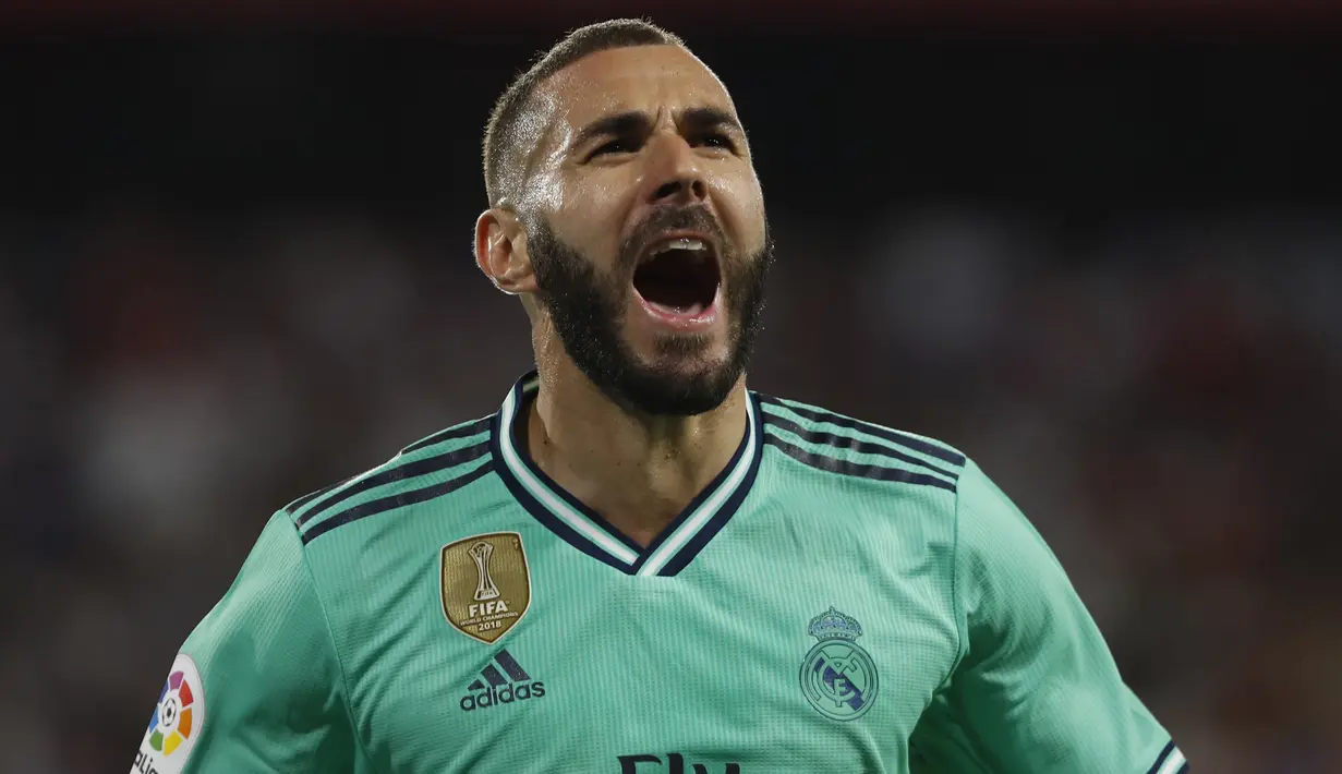 Penyerang Real Madrid, Karim Benzema berselebrasi usai mencetak gol ke gawang Sevilla pada pertandingan lanjutan La Liga Spanyol di stadion Ramon Sanchez Pizjuan (22/9/2019). Gol Benzema di menit ke 64 menjadi satu-satunya gol yang tercipta di pertandingan ini. (AP Photo/Miguel Morenatti)