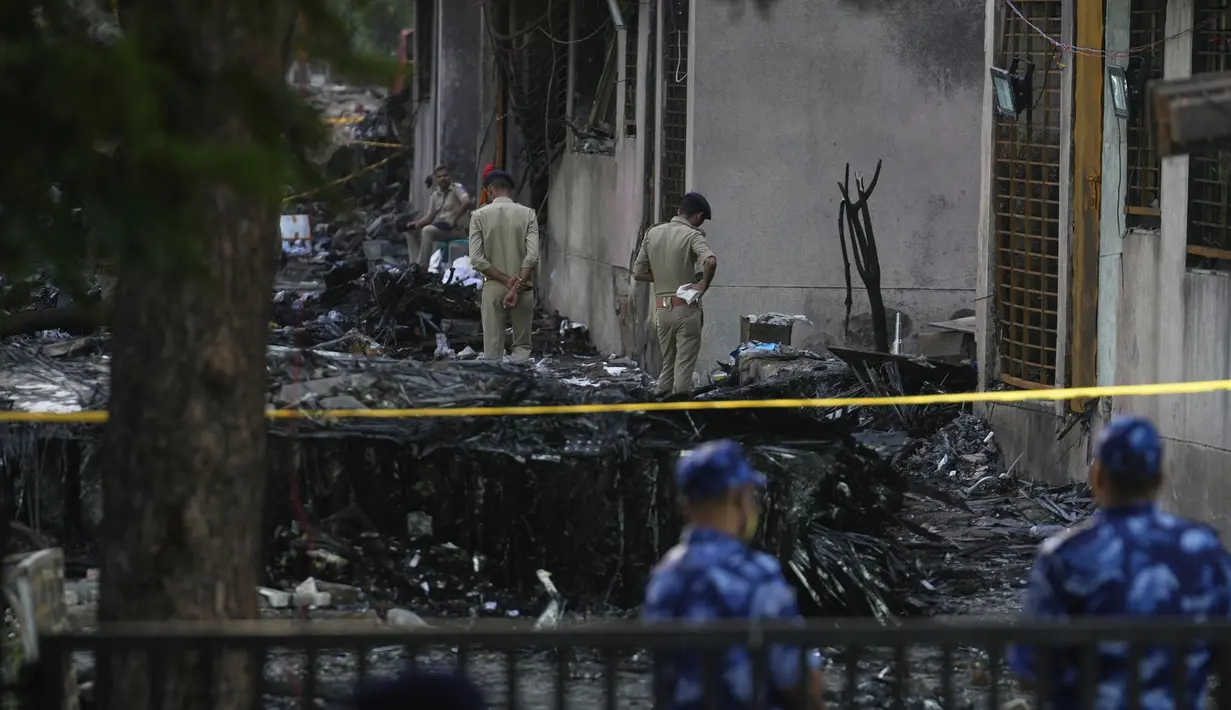 Polisi mengamankan lokasi jatuhnya pesawat di Ahmedabad, India, Jumat 13 Juni 2025. (AP/Rafiq Maqbool)