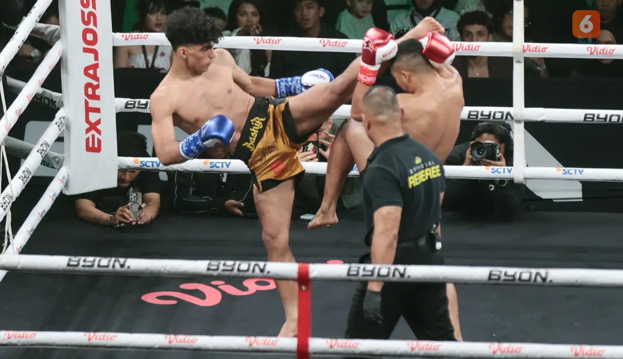 Petarung asal Iran, Bashir, melancarkan high kick yang mengenai kepala Aditya Armagedon dalam laga Byon Combat Showbiz 8 di Tennis Indoor Senayan, Jakarta, Sabtu (29/8/2026). (KLY/Budy Santoso)