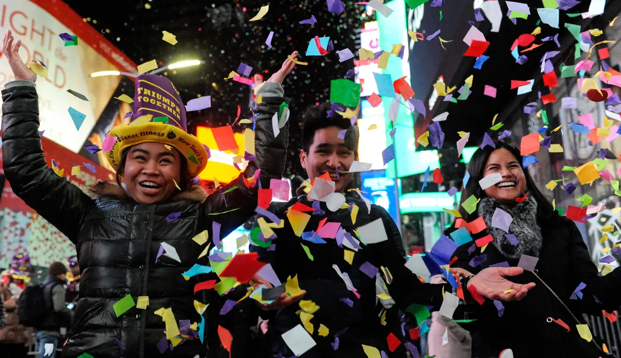 Keceriaan warga setempat saat bermain confetti dalam perayaan tahun baru di Times Square, New York, AS (1/1). Ribuan orang membanjiri Times Square untuk mengikuti acara penghitungan detik-detik pergantian tahun. (Reuters/Stephanie Keith)