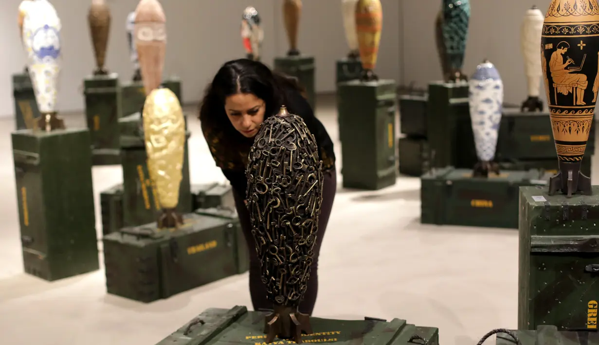 Seorang pengunjung melihat-lihat replika bom warna-warni karya seniman Lebanon, Katya Traboulsi saat dipamerkan di Salih Barakat Gallery, Beirut, Selasa (10/4). (ANWAR AMRO/AFP)