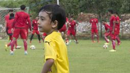 Anak dari Stefano Teco, yang bernama Romario, bermain saat latihan Persija Jakarta di Lapangan Sutasoma, Jakarta, Minggu (25/2/2018). Ketika ayahnya bekerja sang anak asyik bermain sepak bola. (Bola.com/Aspirilla Dwi Adha)