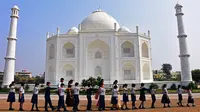 Dalam foto pada 25 November 2021 ini, anak-anak sekolah berjalan melewati replika Taj Mahal selama kunjungan mereka di Burhanpur, negara bagian Madhya Pradesh India. Pengusaha India Anand Prakash Chouksey membangun replika Taj Mahal untuk istrinya. (Uma Shankar MISHRA / AFP)