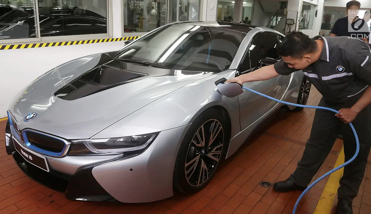 Seorang mekanik tengah mengisi daya BMW i8 saat pembukaan diler baru BMW di Tebet, Jakarta, Selasa (12/12). Diler ini dikhususkan untuk mobil listrik ramah lingkungan BMW i8. (Liputan6.com/Pool/BMW)