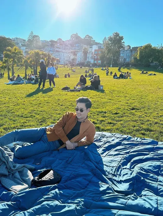 Maudy memotret sang suami saat piknik di taman dengan alas selimut yang hangat. [@maudyayunda]