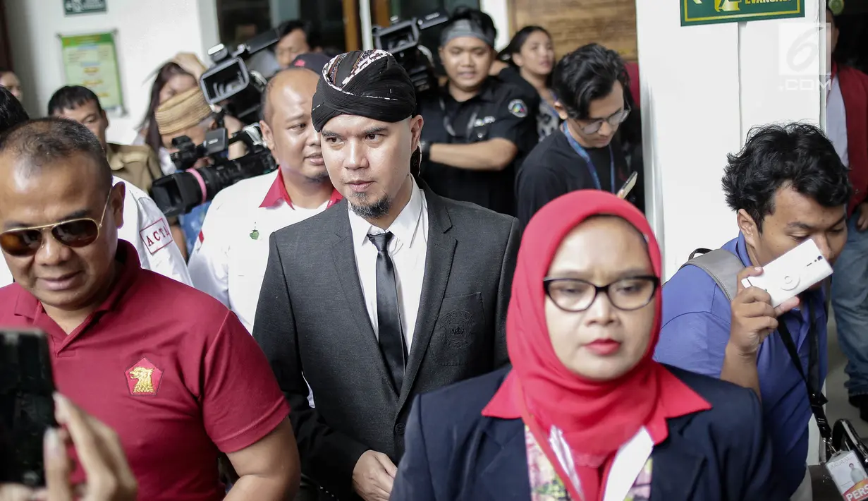 Musikus Ahmad Dhani didampingi kuasa hukumnya meninggalkan lokasi usai menjalani sidang kedua kasus ujaran kebencian  di PN Jakarta Selatan, Senin (23/4). (Liputan6.com/Faizal Fanani)