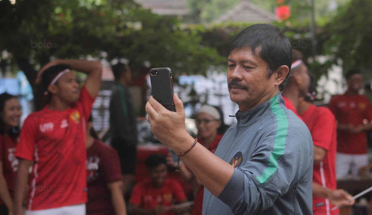 Pelatih Timnas U-19 Indonesia, Indra Sjafri memotret aksi anak asuhnya saat mengikuti lomba menyambut HUT RI ke-72 di Yogyakarta, (17/8/2017). Yogyakarta menjadi pilihan Timnas U-19 untuk melakukan TC. (Bola.com/Ronald Seger)
