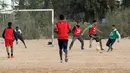 Sejumlah pria bermain sepak bola di lapangan tanah sebelum buka puasa selama bulan Ramadhan, di ibu kota Libya, Tripoli (24/4/2021). (AFP/Mahmud Turkia)