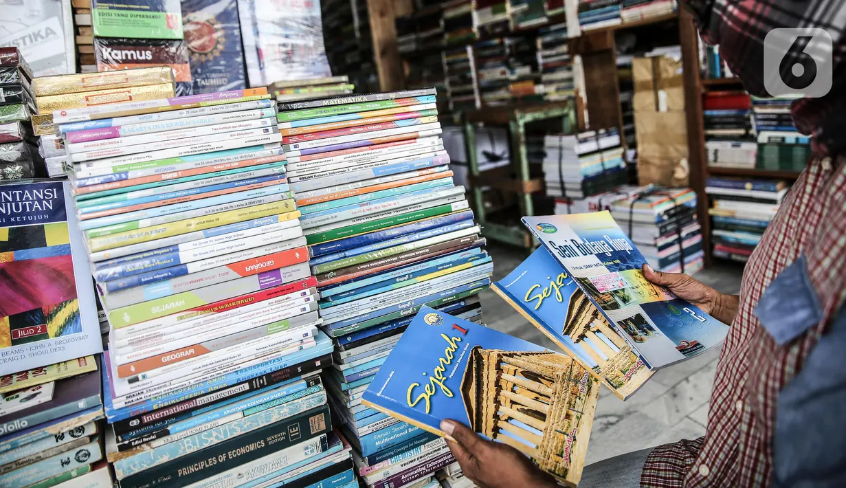 Pedagang menunjukkan buku dagangannya di kawasan Kwitang Jakarta, Jumat (26/6/2020). Sejumlah pedagang mengaku penjualan buku mengalami penurunan hingga 50 persen karena imbauan Pemerintah untuk tinggal dirumah dan libur sekolah selama pandemi COVID-19. (Liputan6.com/Faizal Fanani)