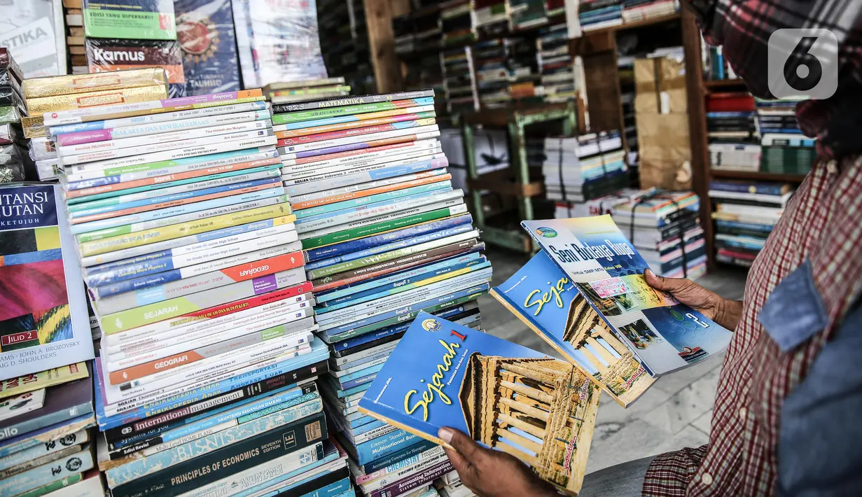 Pedagang menunjukkan buku dagangannya di kawasan Kwitang Jakarta, Jumat (26/6/2020). Sejumlah pedagang mengaku penjualan buku mengalami penurunan hingga 50 persen karena imbauan Pemerintah untuk tinggal dirumah dan libur sekolah selama pandemi COVID-19. (Liputan6.com/Faizal Fanani)