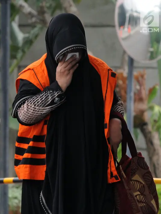Anggota DPRD Kota Malang Een Ambarsari menutupi wajah saat tiba di Gedung KPK, Jakarta, Selasa (2/10). Een menjalani pemeriksaan terkait dugaan menerima suap pembahasan APBD-P Pemkot Malang Tahun Anggaran 2015. (Merdeka.com/Dwi Narwoko)
