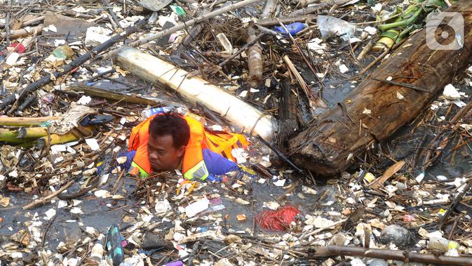 Petugas gabungan membersihkan tumpukan sampah yang menyumbat aliran air Sungai Cikeas di kawasan Bendung Koja Jatiasih, Bekasi, Jawa Barat, Rabu (16/10/2019). Pembersihan sekitar 1.200 meter kubik sampah bambu tersebut diperkirakan menghabiskan waktu dua minggu. (merdeka.com/Arie Basuki)