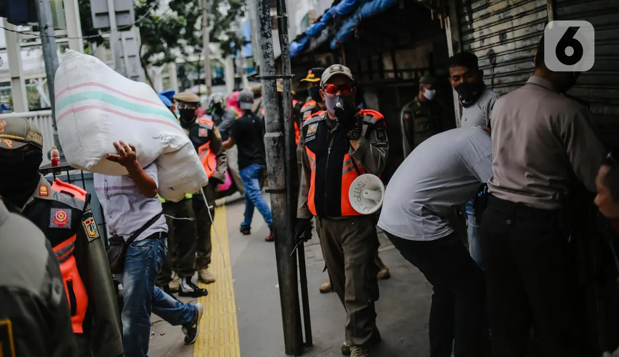 Petugas gabungan menertibkan pedagang yang nekat berjualan saat masa pandemi COVID-19 di kawasan Pasar Tanah Abang, Jakarta, Jumat (22/5/2020). Gubernur DKI Jakarta Anies Baswedan menambah PSBB selama 14 hari mulai tanggal 22 Mei 2020. (Liputan6.com/Faizal Fanani)