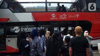 Warga antre untuk menaiki bus tingkat Transjakarta dengan atap terbuka di Jakarta, Selasa (10/5/2022). Bus wisata tersebut beroperasi pukul 10.00-21.00 WIB dengan rute Jakarta Modern (BW2) rute Juanda-Istiqlal (PP) dan Pencakar Langit (BW4) rute Irti-Monas (PP) hingga 11 mei 2022. (merdeka.com/Imam Buhori)