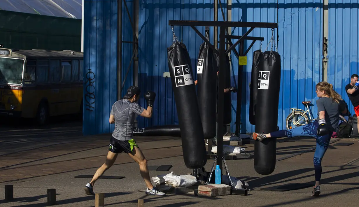 Kickboxer menjaga jarak 1,5 meter mengikuti peraturan protokol kesehatan virus corona COVID-19 pemerintah Belanda saat mereka berlatih di luar ruangan di Amsterdam, Belanda, Selasa (30/3/2021). Kasus COVID-19 di Belanda telah menembus satu juta lebih. (AP Photo/Peter Dejong)