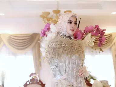 Syahrini berpose mengenakan gamis mewah berwarna krem dengan hiasan rumbai-rumbai di pundak. (Liputan6.com/Instagram/@princessyahrini)