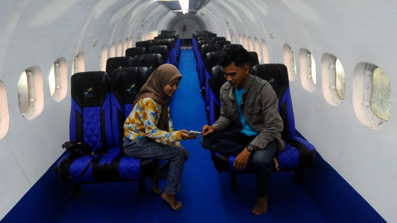 Warga saat berada di kabin penumpang pesawat di kafe Brill's Sky Airport Education and Resto di sekitar area persawahan di Kelurahan Sumbergedong, Trenggalek.