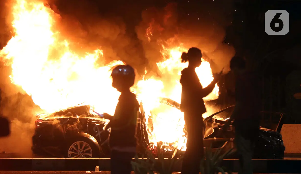 Sebuah mobil plat merah atau mobil dinas dibakar massa di kawasan Gondangdia, Jakarta, Kamis (8/10/2020). Unjuk rasa menentang disahkannya Omnibus Law UU Cipta Kerja berujung aksi anarkis merusak berbagai fasilitas umum. (Liputan6.com/Helmi Fithriansyah)