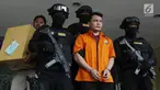 Tersangka pembunuh satu keluarga di Bekasi Haris Simamora (tengah) mendapat pengawalan polisi bersenjata di Polda Metro Jaya, Jakarta, Kamis (21/2). Polda Metro Jaya melimpahkan berkas perkara kasus Haris ke Kejari Bekasi. (Merdeka.com/Imam Buhori)