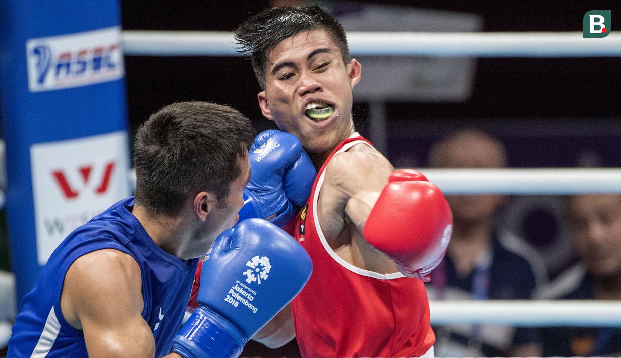 Aksi petinju asal Indonesia Sunan Agung Amoragam saat melawan Mirazizbek Mirzakhalilov asal Uzbekistan di babak semifinal kelas bantam (56 kg) Asian Games 2018 di JIExpo Kemayoran Jakarta pada Jumat (31/8/2018). (Bola.com/Peksi Cahyo)