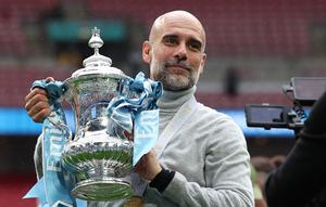 Pelatih Manchester City, Pep Guardiola berfoto dengan Piala FA setelah mengalahkan Chelsea dengan skor 1-0 di partai final di Wembley Stadium hari Sabtu (16/05/2026) malam WIB. (AFP/Adrian Dennis)