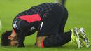 Penyerang Liverpool, Mohamed Salah, melakukan selebrasi sujud syukur usai mencetak gol ke gawang West Ham United pada laga Liga Inggris di Stadion London, Minggu (31/1/2021). Liverpool menang dengan skor 3-1. (Clive Rose/Pool via AP)