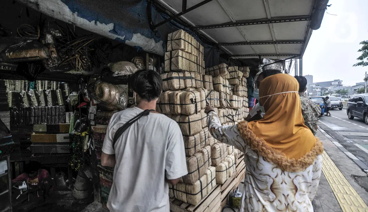 Pedagang saat melayani calon pembeli besek bambu di kawasan Jatinegara, Jakarta, Senin (19/7/2021). Penurunan penjualan besek bambu akibat masih merebaknya Covid-19 serta berbagai larangan dalam aturan PPKM Darurat. (merdeka.com/Iqbal S. Nugroho)