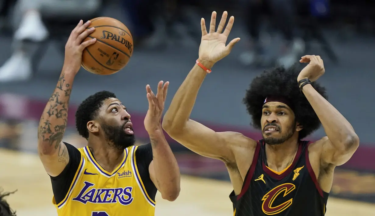 Pebasket LA Lakers, Anthony Davis (kiri) saat akan melempar bola ke ring dalam laga lanjutan babak reguler NBA melawan Cleveland Cavaliers di Quicken Loans Arena, Selasa (26/1/2021). (Foto: AP Photo/Tony Dejak)