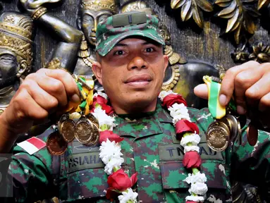 Letnan Dua Inf Poltak Siahaan menunjukkan medali yang diraihnya di ajang Australian Army Skill and Arms Meeting (AASAM) 2016, Banten, Senin (23/5/2016). TNI AD menjadi juara umum dengan meraih 23 medali emas. (Liputan6.com/Helmi Fithriansyah)
