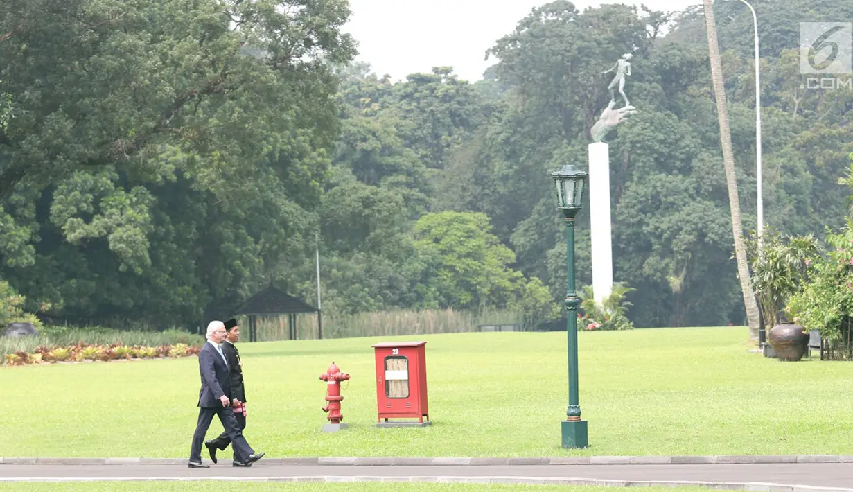 Presiden Joko Widodo berjalan mendampingi Raja Carl XVI Gustaf melintasi taman di halaman belakang Istana Bogor, Jawa Barat, Senin (22/5). (Liputan6.com/Angga Yuniar)