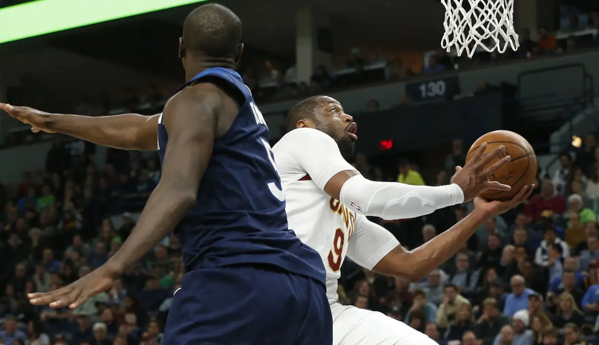 Cleveland Cavaliers, Dwyane Wade (kanan) berusaha melakukan lay up melewati pemain Minnesota Timberwolves, Gorgui Dieng pada laga NBA basketball game di Target Center, Minneapolis, (8/1/2018). Minnesota menang 127-99. (AP/Jim Mone)