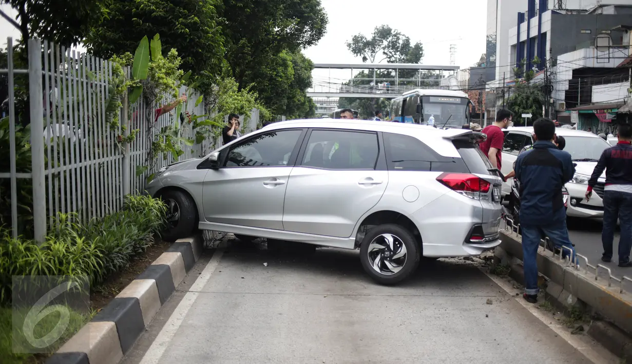 Sebuah mobil menabrak separator busway matraman arah kampung melayu, Jakarta, Sabtu (25/2). Diduga pengemudi kehilangan kendali yang akhirnya mengakibatkan menabrak separator busway. (Liputan6.com/Faizal Fanani)