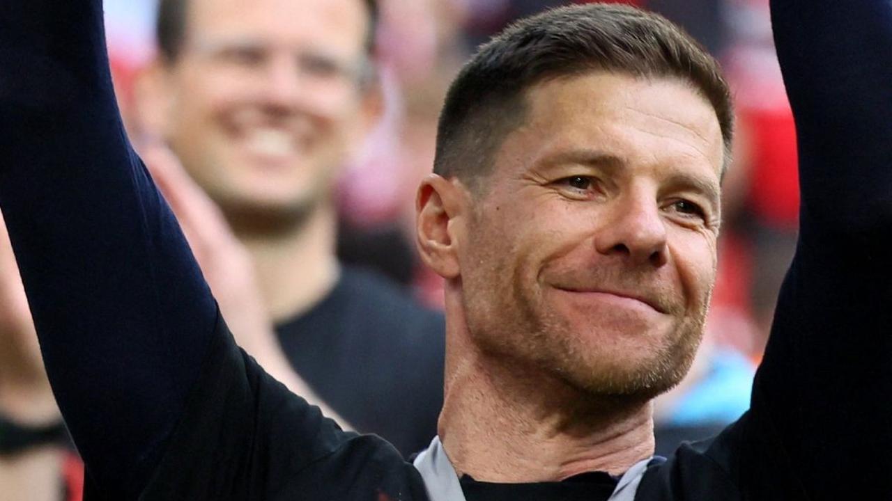 Senyum Xabi Alonso mengangkat trofi juara Bundesliga 2023/2024 yang diraih Bayer Leverkusen. Foto:&nbsp;REUTERS/Wolfgang Rattay